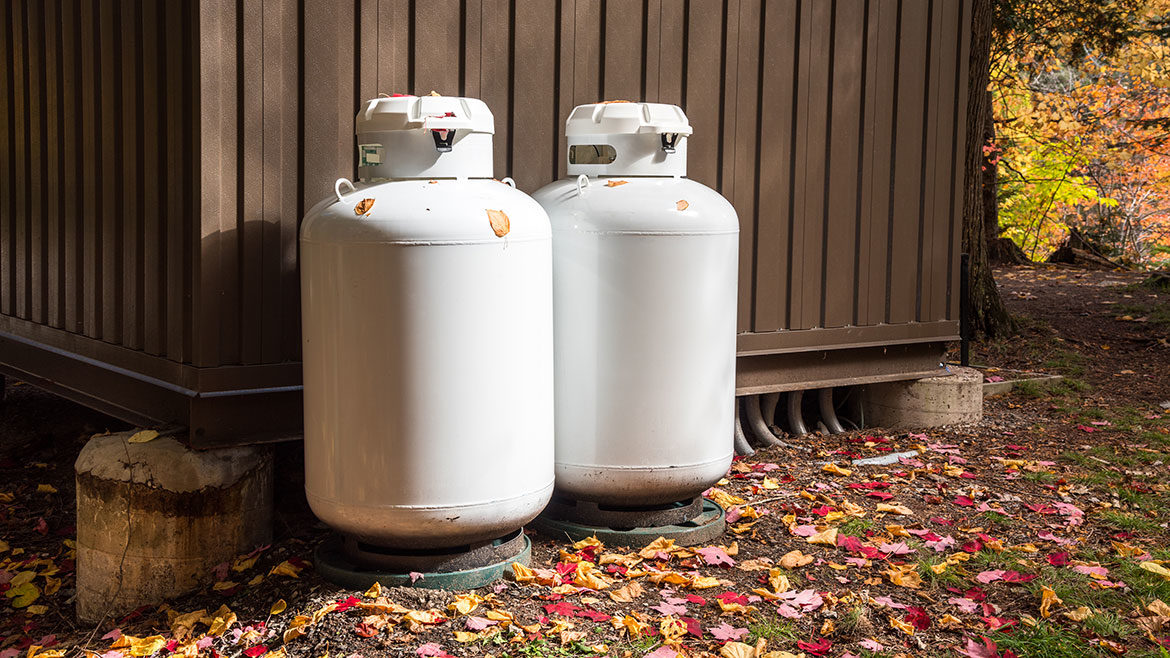 Propane cylinders outside a metal forest hut in autumn