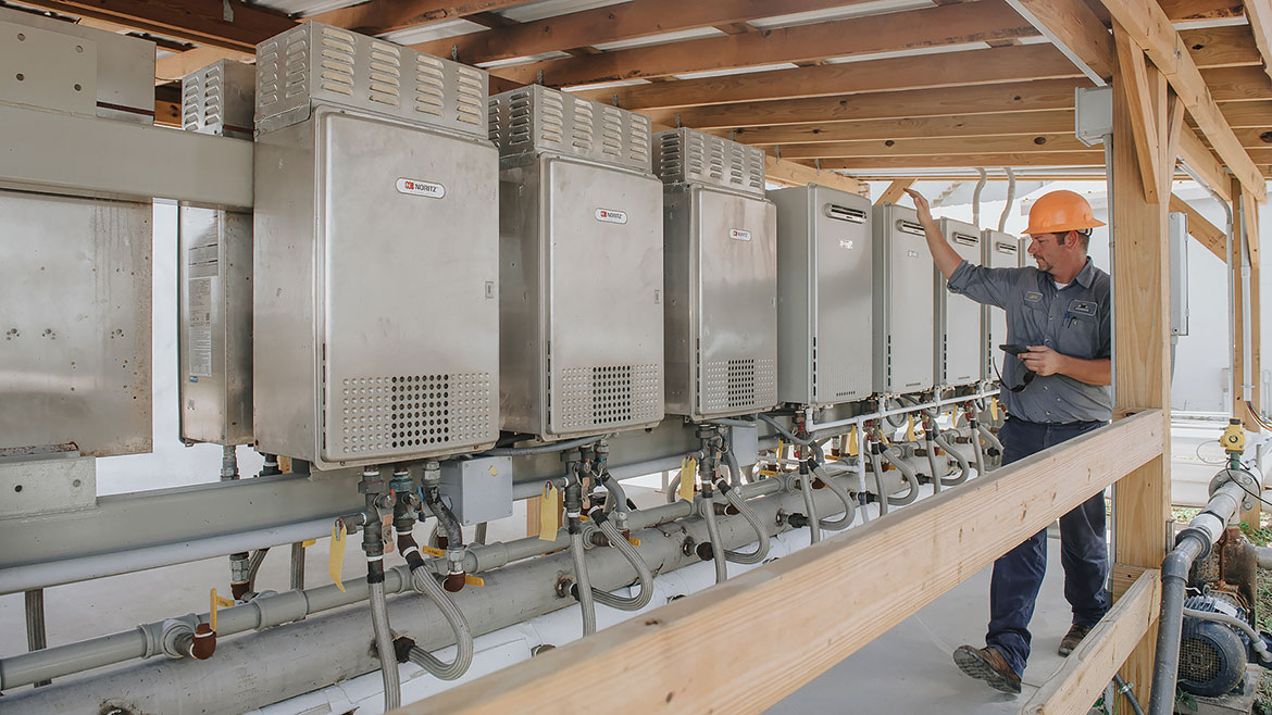 Jeff Beard, maintenance supervisor for liquid operations, looking over 17-unit Noritz tankless, on-demand system at Wedgeworth facility in Lake Placid, Florida.