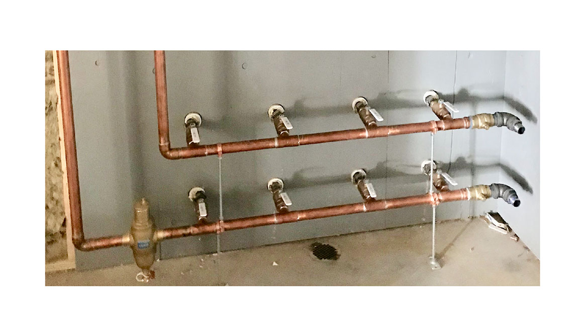 Figure 5. Several geothermal earth loops using an interior site-built manifold constructed of copper tubing.